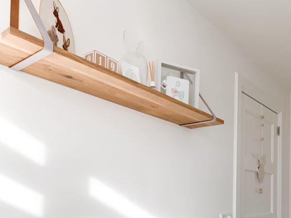 Sfeerfoto van babykamer met een massief eiken wandplank met rechte kant. Bij woodstyles hebben we vele verschillende maten eiken wandplanken met rechte of boomstamkant voor scherpe prijzen. Woodstyles levert snel in zowel België als Nederland